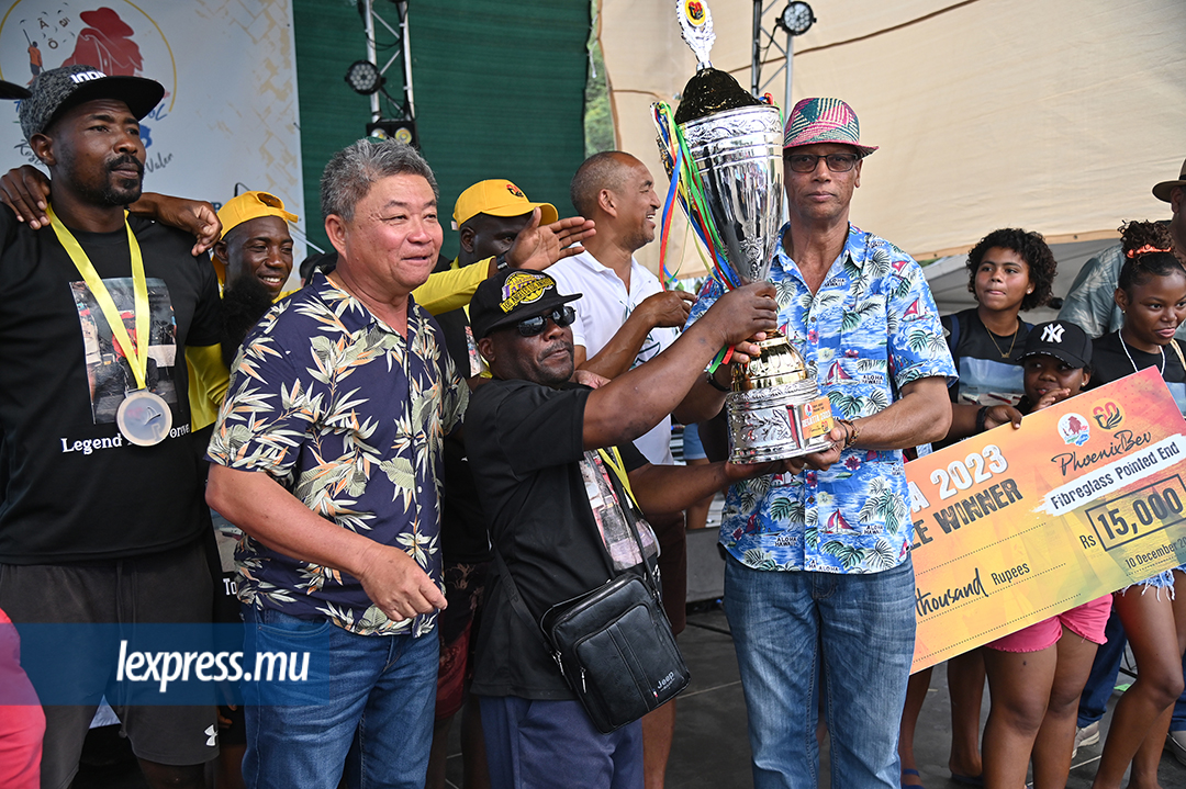 Le commissaire aux Arts et à la Culture, Joseph Varok Ravina, et celui au Tourisme, Jean Alain Wong So, présentant le trophée à Abdool (Cyclone) pour sa victoire dans la catégorie des bateaux en fibre de verre 21’6.